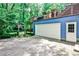 Exterior shot of a house with a large garage and a deck accessible by stairs, surrounded by lush landscaping at 2639 Acorn Ne Ave, Atlanta, GA 30305
