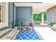 Inviting covered patio featuring rocking chairs, blue accent pillows, and an outdoor rug at 2639 Acorn Ne Ave, Atlanta, GA 30305