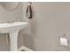 Powder room with a pedestal sink, a towel, and a toilet paper holder against neutral wall at 5439 Alanis Se Pl # 17, Mableton, GA 30126