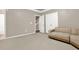 Living room with neutral colored walls, tan carpet and sofa, with a staircase and closet in the background at 5439 Alanis Se Pl # 17, Mableton, GA 30126