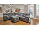 Living room with a large grey sectional, hardwood floors, and view of the staircase and kitchen at 5439 Alanis Se Pl # 17, Mableton, GA 30126
