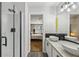 Modern bathroom with double sinks, black accents, and glass-enclosed shower at 7077 Biltmore Trce, Lithonia, GA 30058