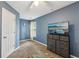 Comfortable bedroom with TV and carpeting; bathed in soft natural light at 7077 Biltmore Trce, Lithonia, GA 30058