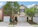 Charming two-story townhome featuring a one-car garage, well-maintained lawn, and mature landscaping at 7077 Biltmore Trce, Lithonia, GA 30058