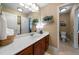 Bathroom featuring a large mirror, wood vanity, a walk-in closet and a toilet, offering a functional space at 7251 Bluewater Ln, Douglasville, GA 30135