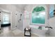 Bright bathroom featuring a soaking tub under an arched window and a glass-enclosed shower at 7251 Bluewater Ln, Douglasville, GA 30135
