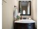 Bathroom vanity with a dark wood cabinet, marble countertop, decorative mirror, and fresh white towels, providing a clean and stylish look at 7251 Bluewater Ln, Douglasville, GA 30135