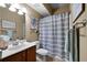 Bathroom with a stylish vanity, commode, and shower/tub with gray striped curtain at 7251 Bluewater Ln, Douglasville, GA 30135