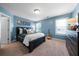 Blue bedroom featuring a dark wood bed, bedside lamps, a dresser, and a window, offering a peaceful retreat at 7251 Bluewater Ln, Douglasville, GA 30135