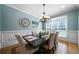 Formal dining room with wainscoting, modern chandelier, and table set for a meal at 7251 Bluewater Ln, Douglasville, GA 30135