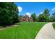 Expansive front yard with well manicured lawn and a long driveway leading to a beautiful brick home at 7251 Bluewater Ln, Douglasville, GA 30135