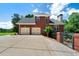 Brick home featuring a two-car garage, black roof and fence, and well-maintained landscaping at 7251 Bluewater Ln, Douglasville, GA 30135
