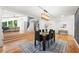 Open-concept dining area with hardwood floors, modern chandelier, and a view of the living room at 2155 Venetian Sw Dr, Atlanta, GA 30311