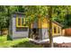 View of the home's modern design with gray siding, wooden window trim, and well-maintained lawn at 2155 Venetian Sw Dr, Atlanta, GA 30311