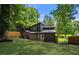 Back of modern home with well-manicured lawn and wooded surroundings at 2155 Venetian Sw Dr, Atlanta, GA 30311