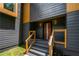A modern front entrance featuring a wood door, gray siding, and natural wood trim accents at 2155 Venetian Sw Dr, Atlanta, GA 30311