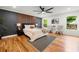 Relaxing main bedroom with a feature wall, ceiling fan, hardwood floors, and natural lighting at 2155 Venetian Sw Dr, Atlanta, GA 30311