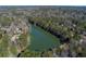Stunning aerial view of a serene lake surrounded by lush trees and beautiful homes, creating a picturesque landscape at 295 Lakemont Dr, Roswell, GA 30075