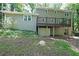 Backyard view of a two-story home featuring a deck overlooking a large grassy yard with mature trees at 295 Lakemont Dr, Roswell, GA 30075