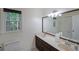 Bathroom with double vanity, large mirrors, and a view of the trees outside the window at 295 Lakemont Dr, Roswell, GA 30075