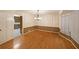 Bright dining room featuring hardwood floors, wainscoting, modern chandelier and an adjoining kitchen at 295 Lakemont Dr, Roswell, GA 30075
