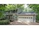 Charming two-story home with a two car garage and a welcoming front porch surrounded by lush greenery at 295 Lakemont Dr, Roswell, GA 30075