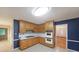 Kitchen with light wood cabinetry, tile floors, white countertops, and blue walls at 295 Lakemont Dr, Roswell, GA 30075