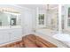 Bright bathroom features a soaking tub with chandeliers and lots of natural light at 529 Arnold Rd, Lawrenceville, GA 30044
