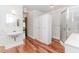 Bright bathroom featuring wood floors, stand-alone sink, closet, and a walk-in shower at 529 Arnold Rd, Lawrenceville, GA 30044