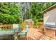 Outdoor deck with dining area, grill, a greenhouse and lush landscaping at 529 Arnold Rd, Lawrenceville, GA 30044