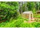 Backyard featuring a greenhouse surrounded by lush, mature landscaping at 529 Arnold Rd, Lawrenceville, GA 30044