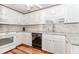 Well-lit kitchen features white cabinets, stainless steel appliances, and hardwood flooring, ideal for cooking at 529 Arnold Rd, Lawrenceville, GA 30044