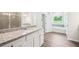 Bathroom with granite vanity, wood flooring, tub, glass shower, and a view of the outside at 1411 Stephens View Dr, Loganville, GA 30052
