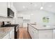 Bright kitchen with white cabinetry, granite countertops, a kitchen island, and stainless steel appliances at 1411 Stephens View Dr, Loganville, GA 30052