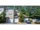 Townhouse exterior with attached garages, a red front door, and mature trees surrounding the property at 2700 Pine Tree Ne Rd # 3009, Atlanta, GA 30324