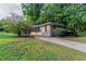 Quaint single-story brick home featuring mature trees, a well-manicured lawn, and a welcoming red front door at 4029 Moffat Ct, Decatur, GA 30035