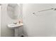 Bathroom with pedestal sink, oval mirror, and towel bar for a minimalist style at 7495 Garnet Dr, Jonesboro, GA 30236