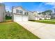 View of homes showing attached garages, driveways, and lawns in a quiet suburban neighborhood at 7495 Garnet Dr, Jonesboro, GA 30236