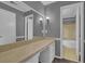 Bathroom with a vanity and cabinets, large mirror, neutral walls with trim, and bath in the background at 9480 Coleman Rd, Roswell, GA 30075