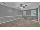 Bright bedroom featuring neutral carpet, light gray walls with white trim, and a ceiling fan for added comfort at 9480 Coleman Rd, Roswell, GA 30075