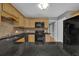 Kitchen featuring black appliances, tile backsplash, and light wood cabinets at 9480 Coleman Rd, Roswell, GA 30075