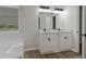 Bathroom showcases a double vanity, bathtub, and wood flooring, creating a bright and functional space at 5383 Biffle Way, Stone Mountain, GA 30088