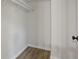 Empty closet with wood-look flooring and white walls, offering a clean and simple storage space at 5383 Biffle Way, Stone Mountain, GA 30088