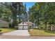 Charming two-story home with a two-car garage, manicured lawn, and mature trees on a sunny day at 5383 Biffle Way, Stone Mountain, GA 30088