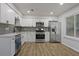 Updated kitchen with stainless steel appliances, white cabinets, and stylish backsplash at 5383 Biffle Way, Stone Mountain, GA 30088