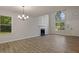 Light filled living room boasts fireplace, large windows, and modern chandelier at 5383 Biffle Way, Stone Mountain, GA 30088