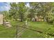 Lush backyard featuring a vintage shed, surrounded by green grass and mature trees at 204 Morris St, Palmetto, GA 30268