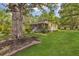Charming yellow house with a screened porch, surrounded by a spacious green lawn and mature trees at 204 Morris St, Palmetto, GA 30268