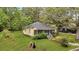 Cozy cottage-style home with a screened front porch, surrounded by lush greenery, on a well-maintained lawn at 204 Morris St, Palmetto, GA 30268