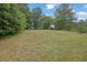 Large, grassy backyard with mature trees and foliage for a peaceful setting at 2530 River Run Dr, Dacula, GA 30019